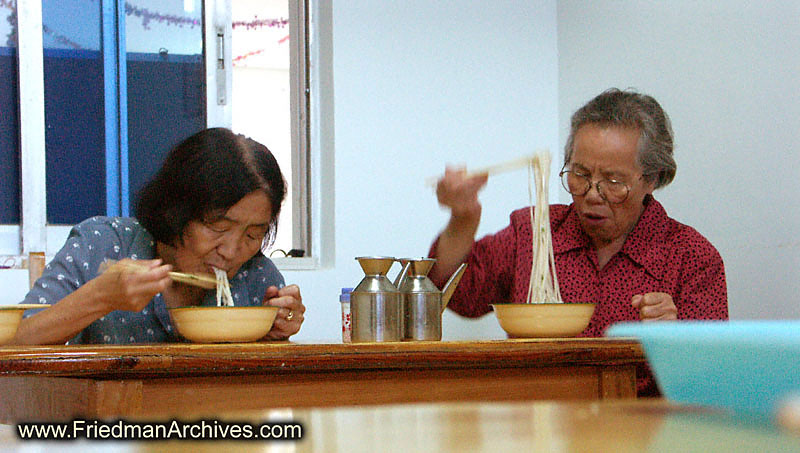 2 old ladies eating lo mein