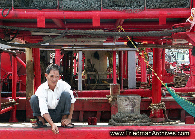 Guy on edge of red boat