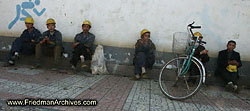 Construction workers sitting next to wall