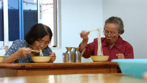 Two old ladies eating Lo Mein.