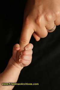 Baby's hand holding mother's finger