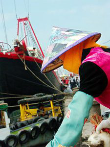 This masked supplier was handing live ducks to one of the boats.